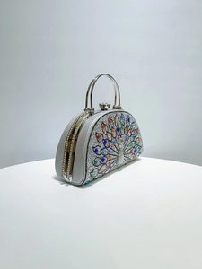 Macro shot of silver peacock evening bag with colorful rhinestones and metal frame