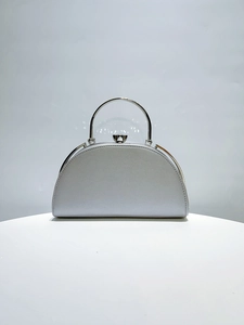 Close-up of sparkling silver evening clutch featuring a metal ring handle and top clasp