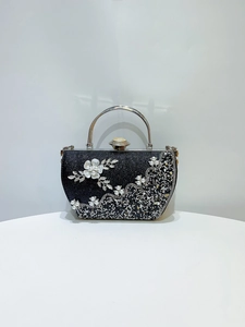 Détail du sac de soirée avec fleurs 3D blanches, perles et strass sur paillettes noires