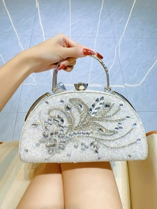 Detailed view of white rhinestone evening bag with silver metal handle for weddings