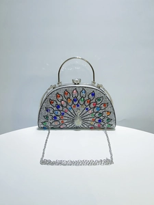 Macro view of crystal peacock evening bag with colorful rhinestones and silver handle
