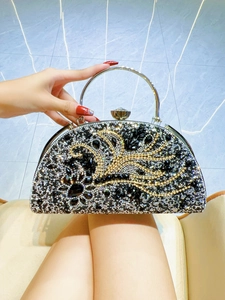 Close-up of elegant evening handbag with sparkling rhinestones and a silver metal ring handle