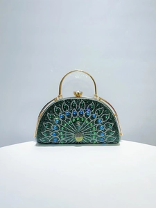Macro view of peacock evening bag featuring sparkling green crystals and gold metal handle