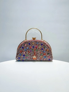 Detail of evening clutch bag with peacock diamond pattern and golden ring handle