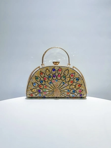 Detailed macro view of peacock rhinestone pattern on luxurious gold evening clutch bag