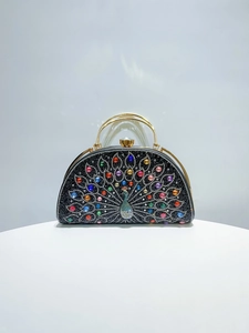 Detail of peacock evening clutch with colorful rhinestones and gold metal handle