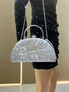 Detail of silver evening clutch with crystal leaf accents and metal ring handle