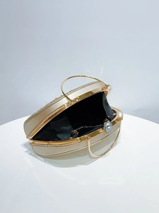 Detailed macro view of champagne gold evening bag with rhinestones and black fabric lining