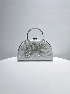 Detailed view of silver evening bag featuring intricate crystal flowers and rhinestones
