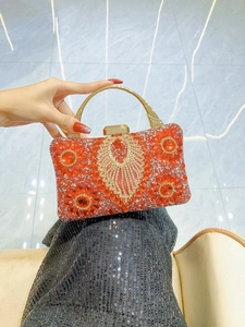 Detailed close-up of a red and gold rhinestone evening bag with intricate crystal patterns