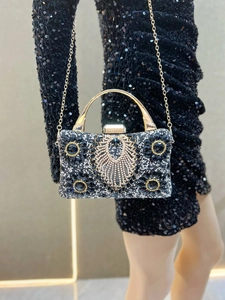 Detailed view of the luxury black evening bag with sparkling rhinestones and gold handle