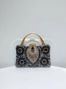 Close-up of luxury black evening clutch featuring intricate floral rhinestone and crystal beadwork