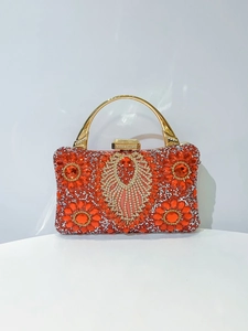Close-up of luxury red rhinestone flower evening bag with elegant golden handle