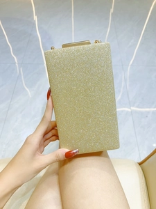 Detail of elegant gold glitter evening clutch bag with metallic clasp closure and chain