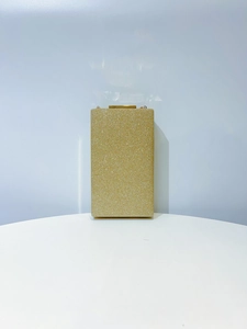 Detail of elegant gold glitter evening clutch bag with metallic clasp and chain hooks