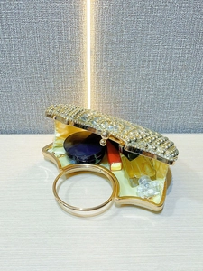 Detail view of gold evening clutch with rhinestones and internal cosmetic space