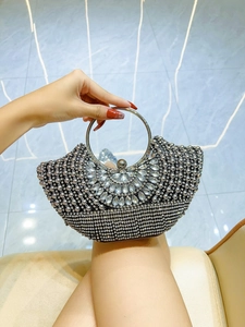 Close-up of semi-circular evening clutch with sparkling silver rhinestones and crystal beads