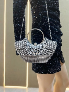 Detail of silver evening bag with radiant crystals, rhinestones and fringe tassels