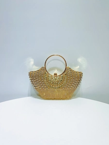 Detailed macro view of luxurious golden evening clutch with rhinestones and round handle