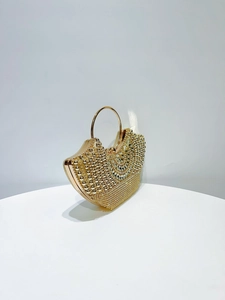 Detailed macro view of the gold evening clutch with rhinestones and round metal handle