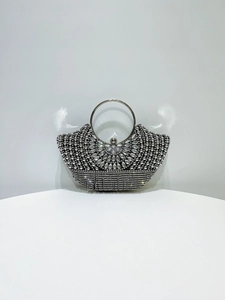 Close-up of sparkling silver evening bag with crystal rhinestones and metal ring handle