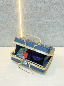 Interior view of navy evening bag showing capacity for perfume, lipstick and cosmetics