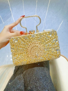 Macro detail of golden peacock pattern on a rhinestone evening bag with crystals