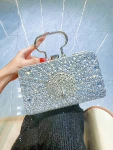 Detail of silver evening clutch bag with sparkling peacock crystal rhinestones design