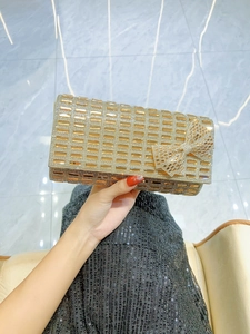 Close-up of golden rhinestone evening clutch featuring a large sparkling crystal bow detail