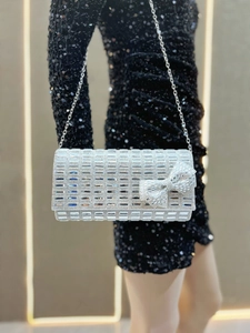 Detail of silver evening clutch with sparkling rhinestones and a crystal bow accent
