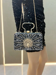 Detailed view of the gold peacock relief and black rhinestone inlay on the evening clutch