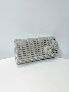 Detail of silver evening clutch with sparkling rhinestones and a large decorative bow