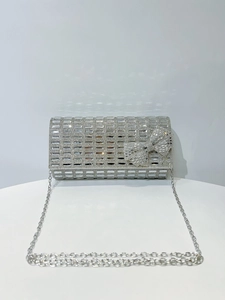 Detail view of silver luxury evening clutch with crystal rhinestones and bow accent