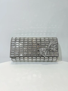 Detail of silver rhinestone clutch bag with a large 3D crystal bow and rectangular sequins
