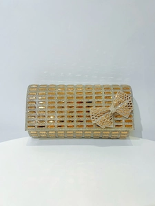 Detailed view of luxury gold evening clutch with rhinestones and a crystal bow accent