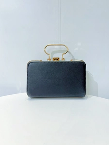 Front view of black rectangular evening clutch bag with elegant golden metal arched handle