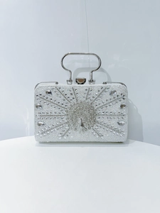 Detailed close-up of crystal peacock evening clutch with silver metal ring handle