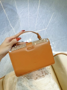 Detailed view of camel leather handbag featuring sparkling rhinestone-encrusted flap