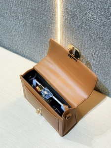 Close-up of brown PU leather shoulder bag with gold hardware showing interior storage space