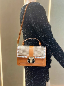 Detail of vintage brown leather handbag with sparkling rhinestone flap and golden lock