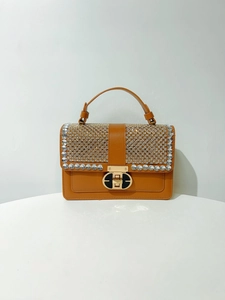 Detail of brown PU leather handbag featuring sparkling rhinestones and gold twist lock