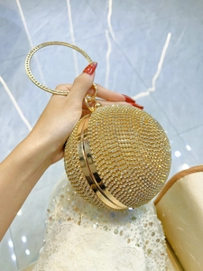 Golden spherical evening bag with sparkling rhinestones and a luxury circular handle