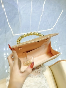 Elegant champagne gold pleated clutch bag with faux pearl handle and metal chain strap