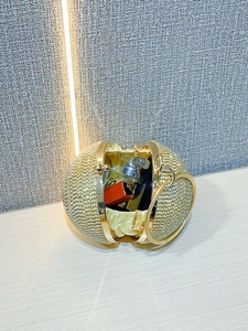 Detail of spherical evening clutch with gold rhinestones showing lipstick storage