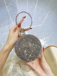 Detailed macro view of a spherical evening bag featuring spiral rhinestones and metal handle