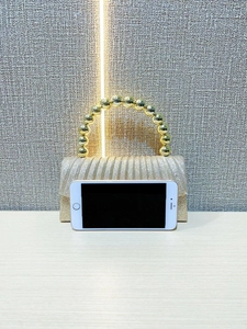 Detail of gold sequin clutch bag with metal bead handle and smartphone for size reference