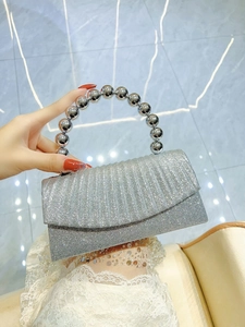 Detailed view of silver sequin evening clutch with metallic ball handle and glitter texture