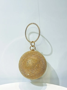 Detail of spherical evening clutch bag with gold rhinestones and crystal ring handle