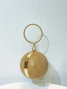 Detail of a gold spherical evening bag featuring shimmering crystals and a circular handle