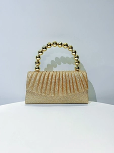 Detail of gold glitter evening clutch with pleated fabric and metallic bead handle